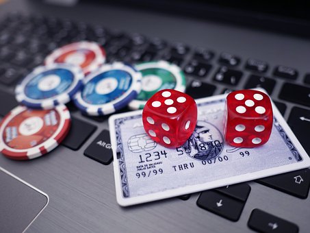 Laptop with casino chips, dice and credit card